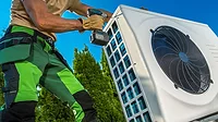 HVAC Technician Installing Large Modern Heat Pump HVAC Technician Installing Large Modern Heat Pump