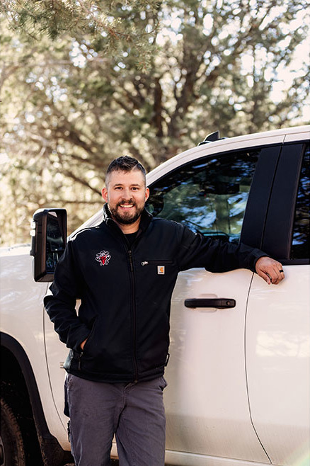 Keefer Rader posing next to his white truck.