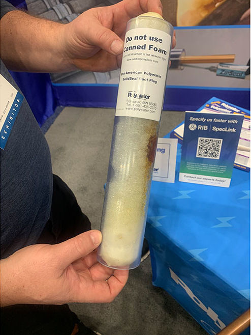 Brian Gunderson at the American Polywater booth holding a SolidSeal Duct Plug.