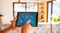 Man using tablet with smart home control functions at home.