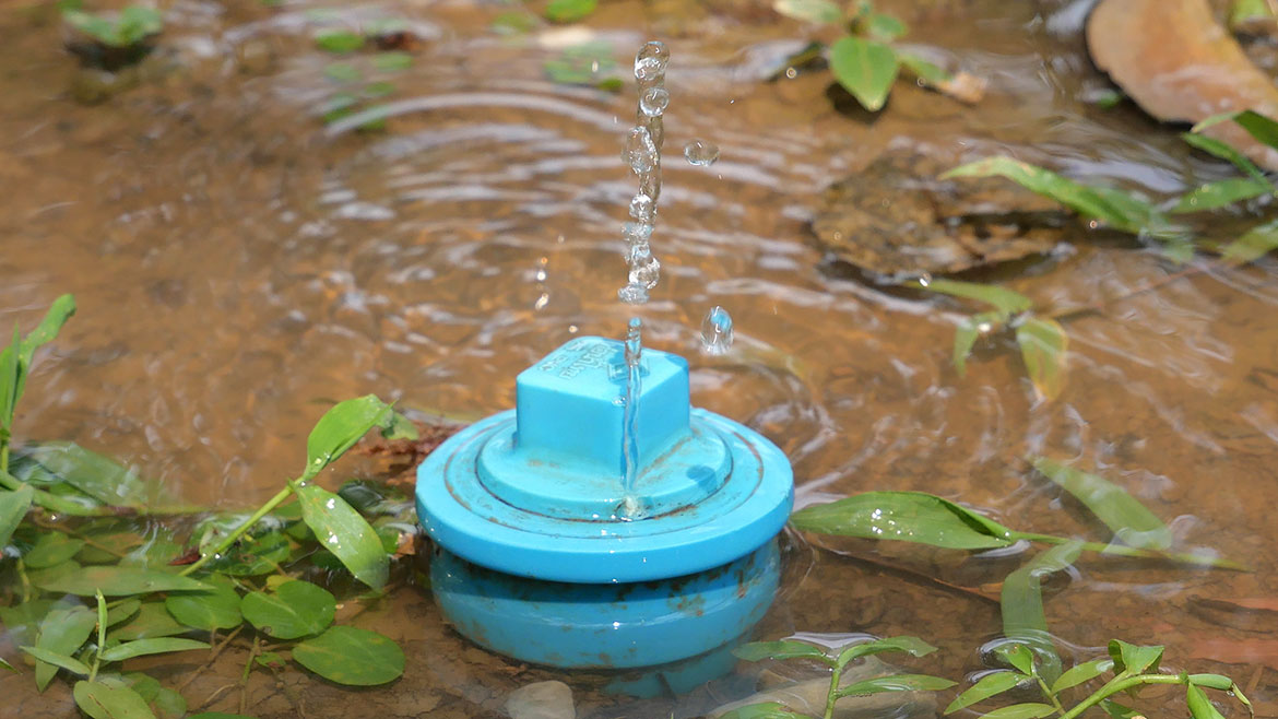 Broken water pipe on the ground causing water to overflow.