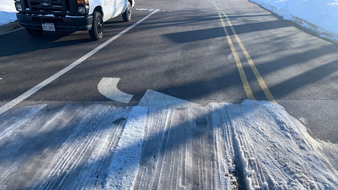 Snow melting on a parking lot turn lane.