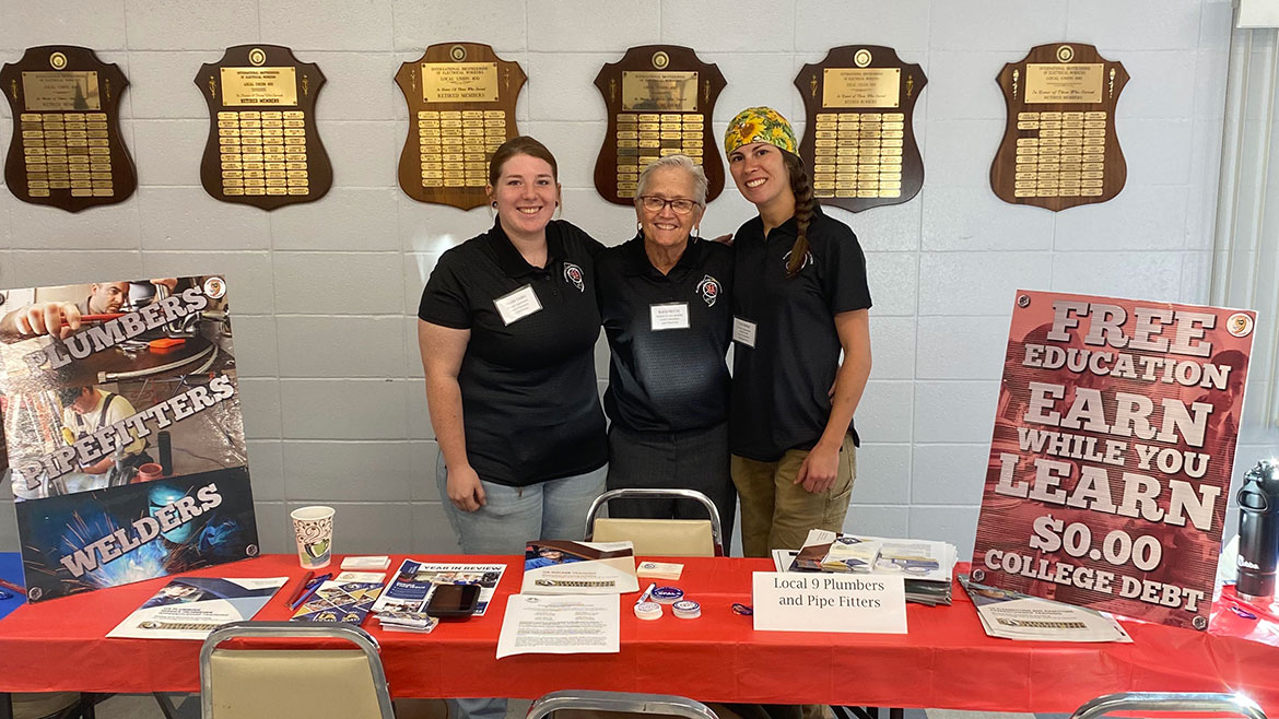 Nicole Linke, Karla Mckoy and Tori Bobal.posing by a presentation table.