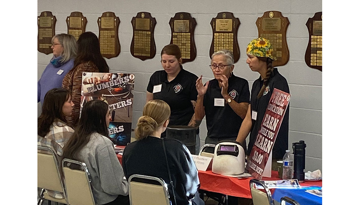 Angela Malaiko, Nicole Linke, Jessica Raymond, Tori Bobal, Michelle Buchanan speaking with a group of seated women.