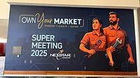 Super Meeting 2025 poster Super Meeting 2025 poster. 'Own Your Market' with illustrated man and woman in plumbing uniform, each holding a wrench.