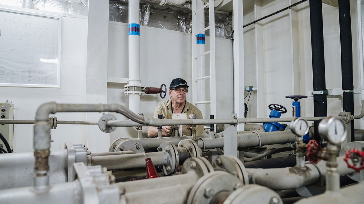  John Lean, Hotel Engineer for Mercy Ships, checking meters in the engine room. © 2024 Mercy Ships