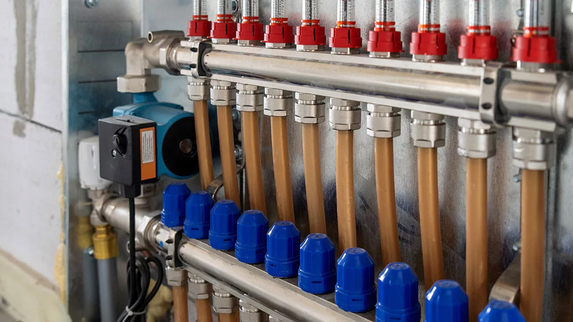 Floor heating manifold cabinet with flowmeter and PEX pipe.
