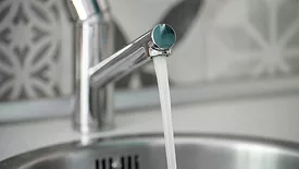 Vivid close-up of a chrome faucet dispensing fresh water, symbolizing hygiene, cleanliness, and home efficiency.