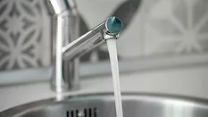 Vivid close-up of a chrome faucet dispensing fresh water, symbolizing hygiene, cleanliness, and home efficiency.