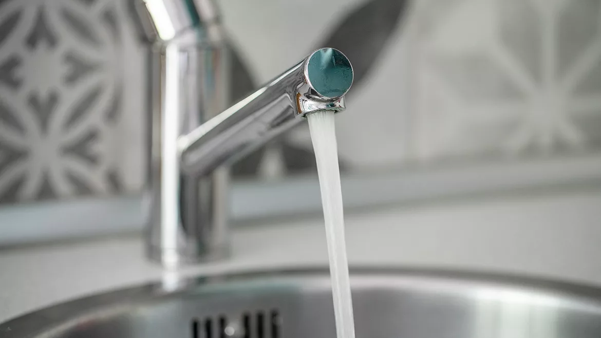 Vivid close-up of a chrome faucet dispensing fresh water, symbolizing hygiene, cleanliness, and home efficiency.