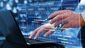 Project manager working on laptop and updating tasks and milestones progress planning with Gantt chart scheduling interface for company on virtual screen.