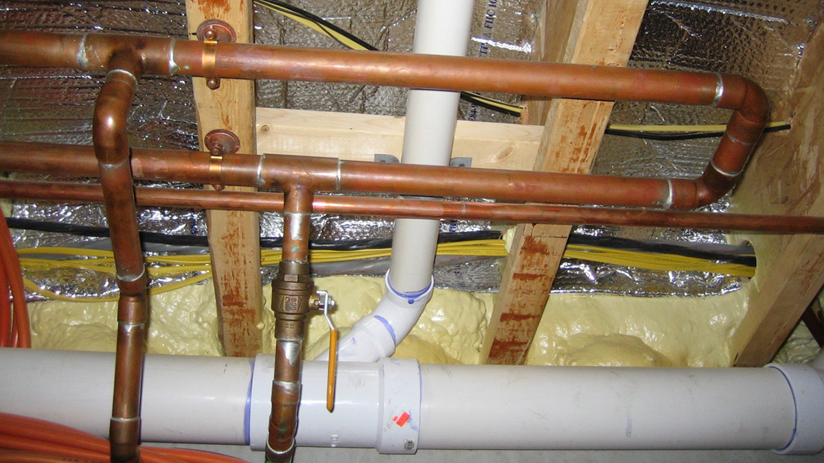 Figure 1: horizontal piping is the end of a “boiler loop” assembled with 1” copper tubing and fastened to the underside of floor framing.