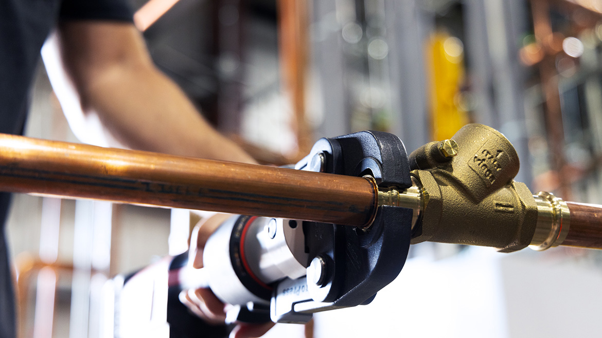 Close-up of a worker using a wrench to work on a modular system.