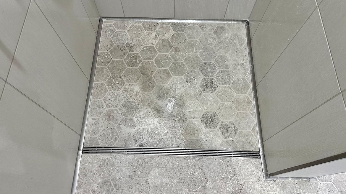 A QuickDrain ProLine Linear shower drain shown in a shower stall.