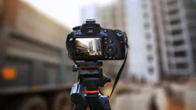 Camera on a tripod taking a shot on construction site.