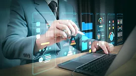 Person in business suit holding a stylus, tapping one of the virtual mobile app windows floating above the laptop.