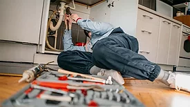 Plumber Working under Sink