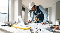 Building contractor looking at data on his laptop Building contractor looking at data on his laptop