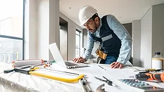 Building contractor looking at data on his laptop