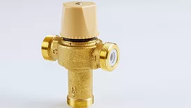 Plumbing connection with close up water brass thermostatic mixing valve isolated on white background.