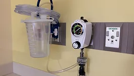 Tools mounted to hospital wall to vacuum fluids from patients.