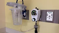 Tools mounted to hospital wall to vacuum fluids from patients.