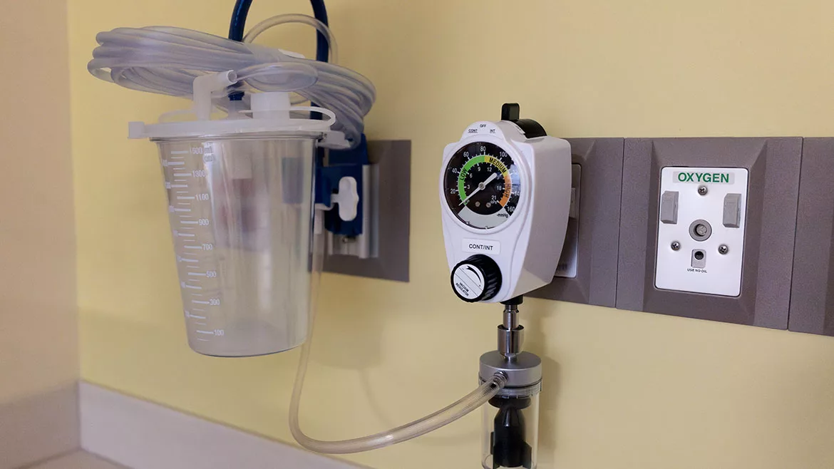Tools mounted to hospital wall to vacuum fluids from patients.