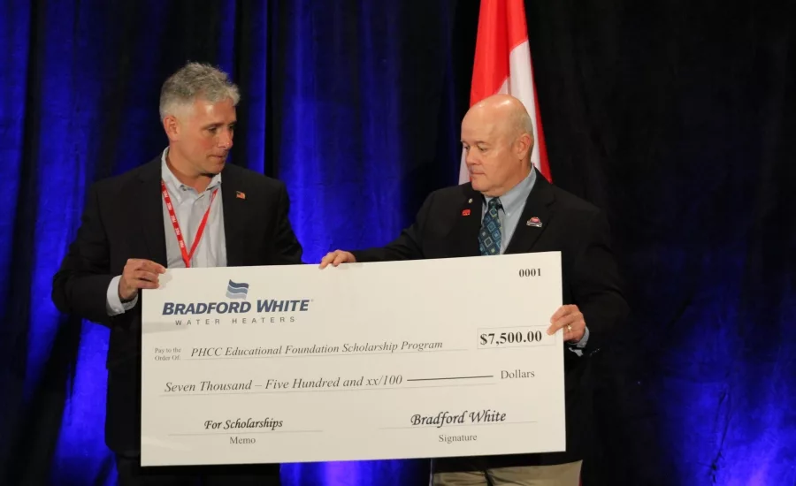 Bradford White Director of Marketing Carl Pinto, left, presents a scholarship check to Craig Lewis, chair of the PHCC Educational Foundation.  Photo credit: Jen Anesi/Plumbing & Mechanical