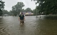 Jason Horcasitas, A.H. Deveney’s inside sales manager, wades through flood waters near his home, which was damaged severely Jason Horcasitas, A.H. Deveney’s inside sales manager, wades through flood waters near his home, which was damaged severely