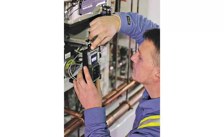 Service Technician Dan Petruzzi checks settings on a Navien NPE-240A