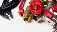 Plumbing equpment parts and wrench on the white background close up.